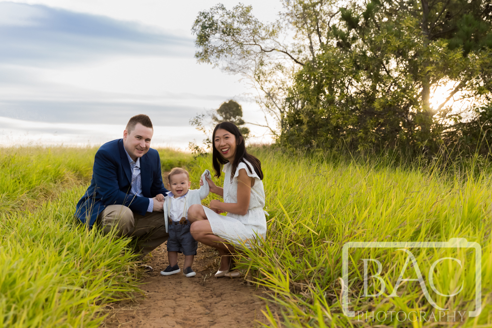 Family of family of 3 on a track with long grass
