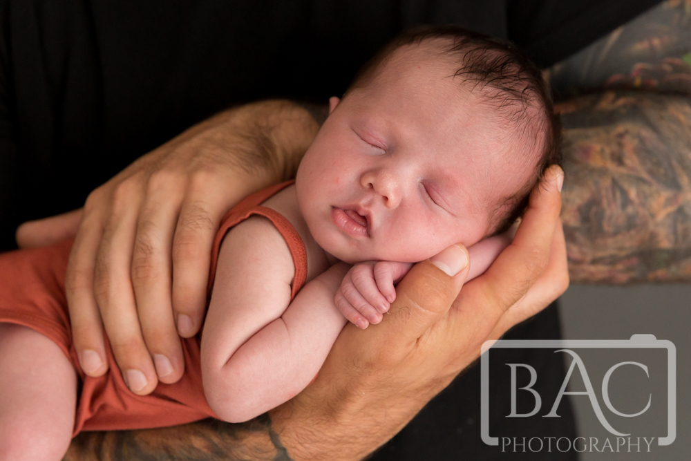 newborn baby girl in dads arms