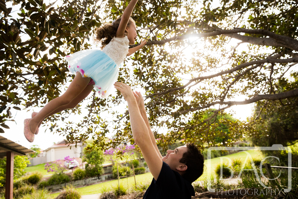 Dad and daughter portrait throwing her up in the air