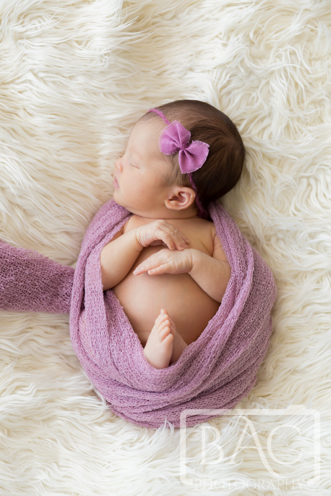 Newborn baby girl in purple wrap