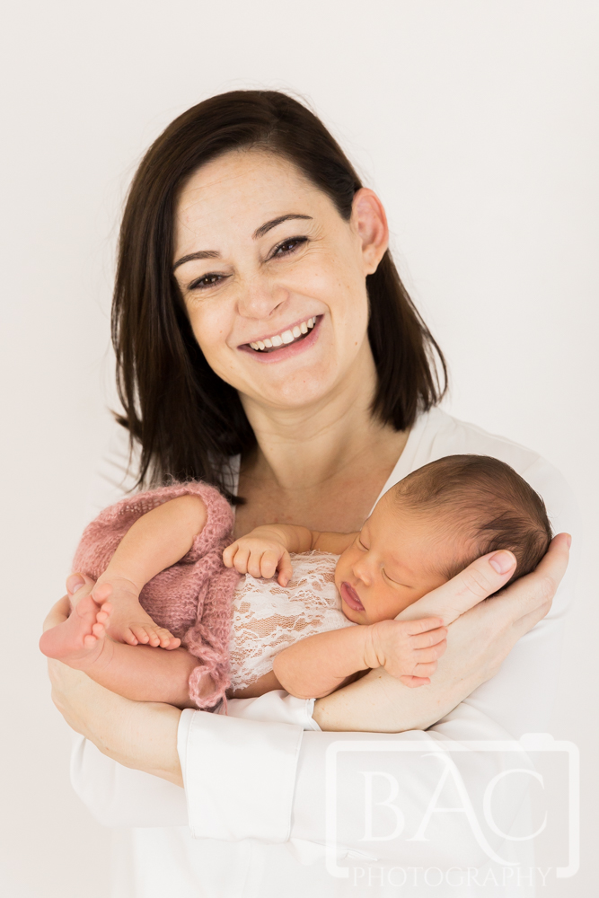 portrait of mum smiling with 10 day old baby girl