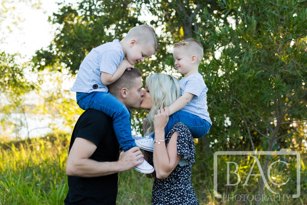 Cute Family portrait mum kissing dad
