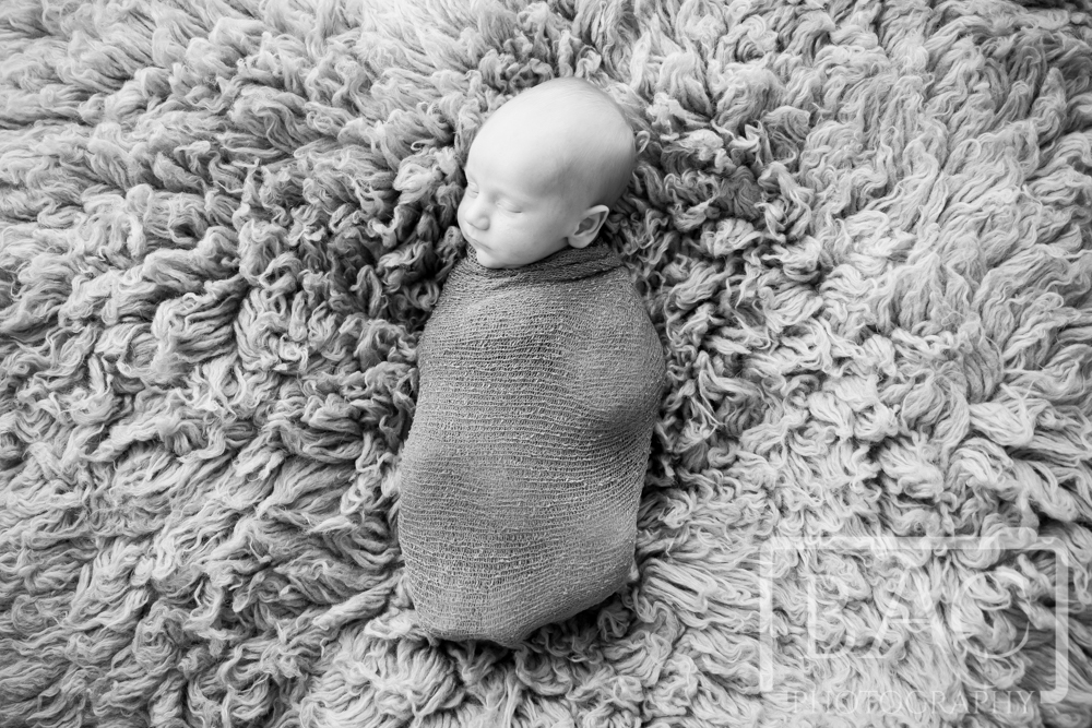 Newborn baby wrapped in black and white