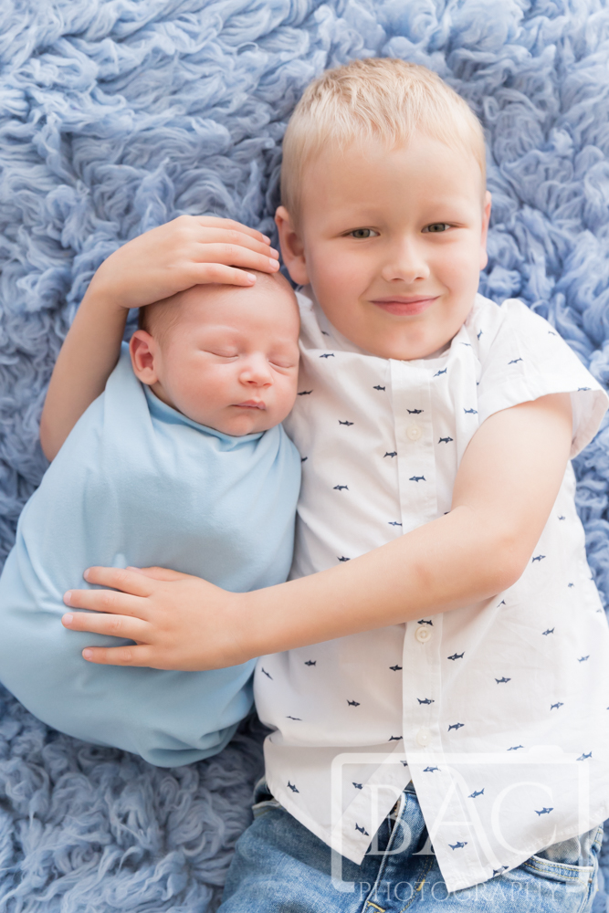 Newborn portrait with big brother holding his baby brother