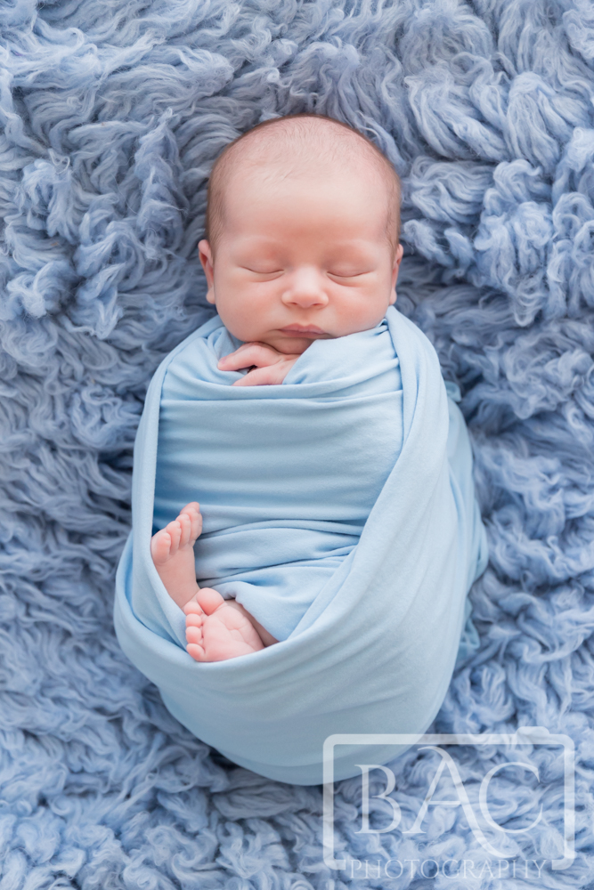newborn baby boy on blue rug