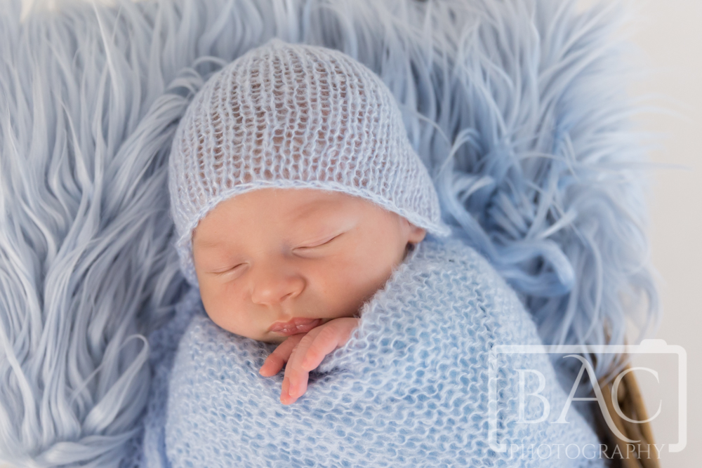 Newborn boy portrait with blue wrap and bonnet