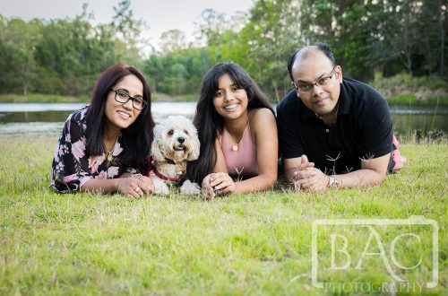 Family portrait with dog lying down outdoor
