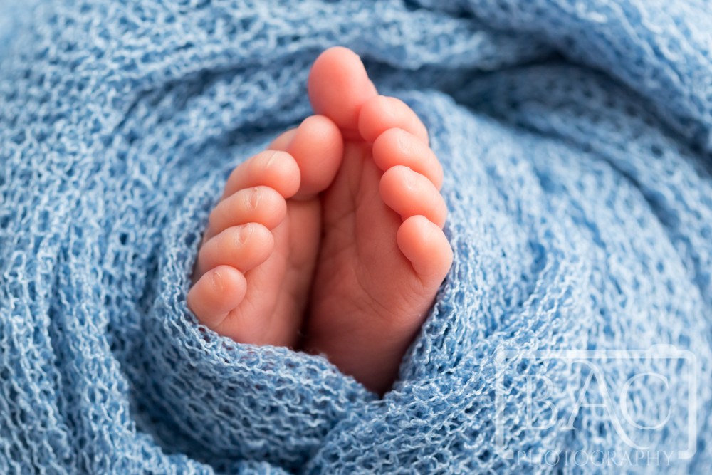 tiny newborn feet in blue