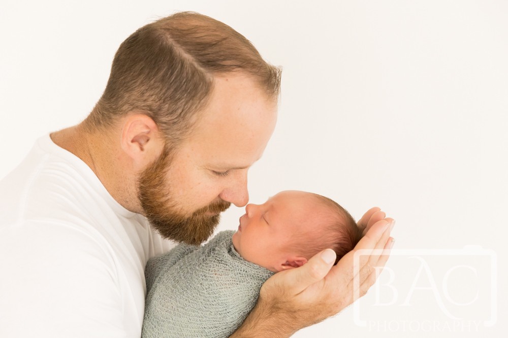 father and newborn baby in studio