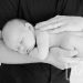 sleeping newborn in dads arms portrait