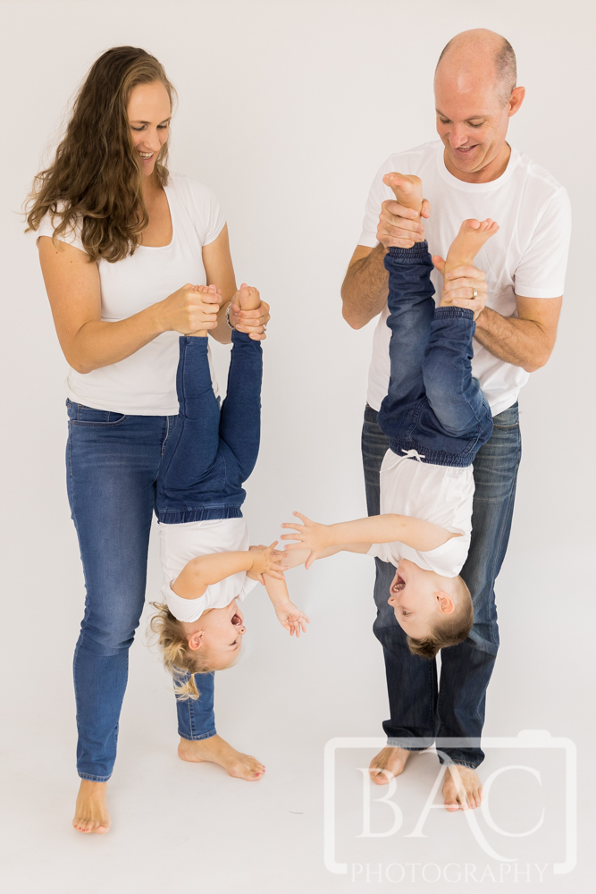 fun studio portrait mum and dad hanging kids upside down