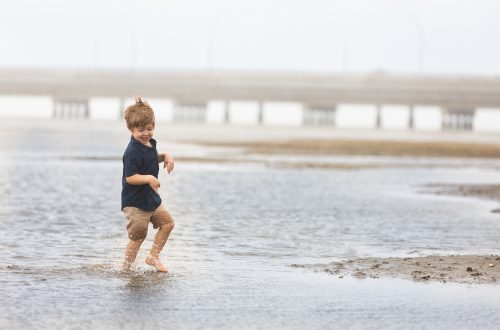 rainy day portrait of boy playing in the water near shorncliffe pier