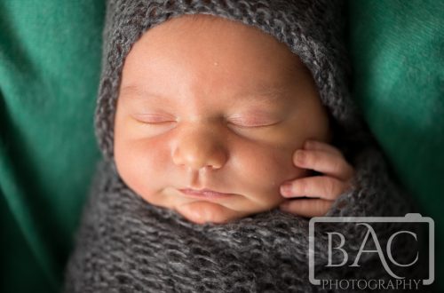 close up swaddled newborn studio portrait