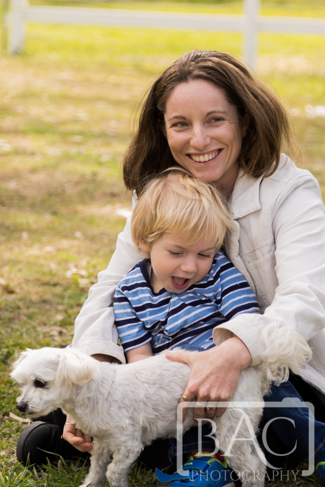 mum and son having fun with pet dog outdoors